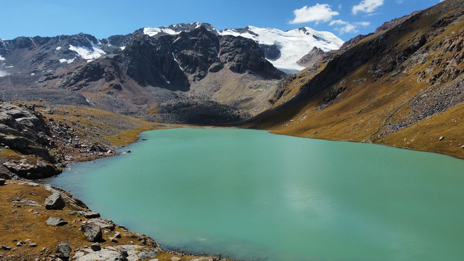 Turquoise Ala-Kul lake below glaciers