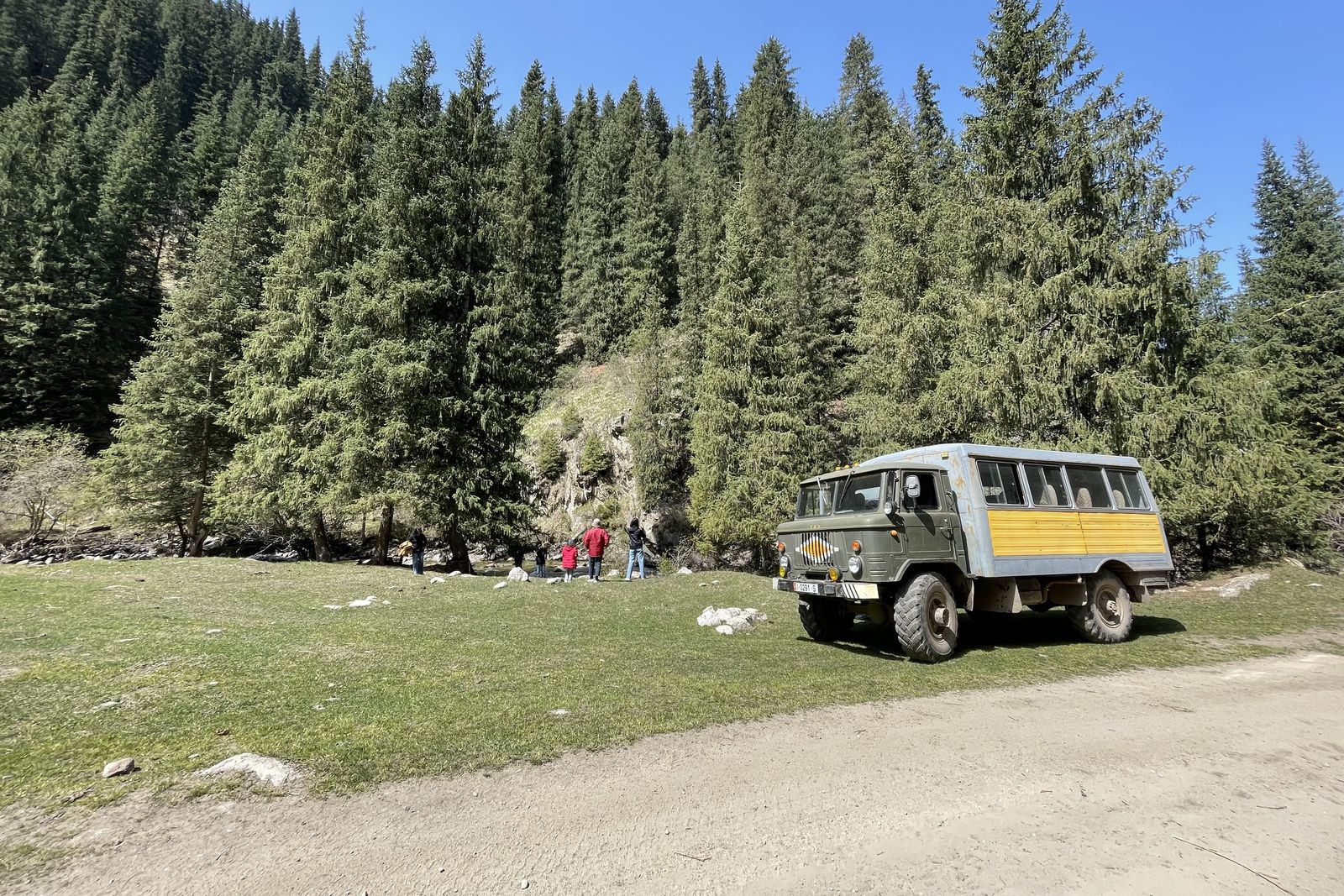 An old Soviet-era truck on the dirt road to Altyn-Arashan, among spruce trees