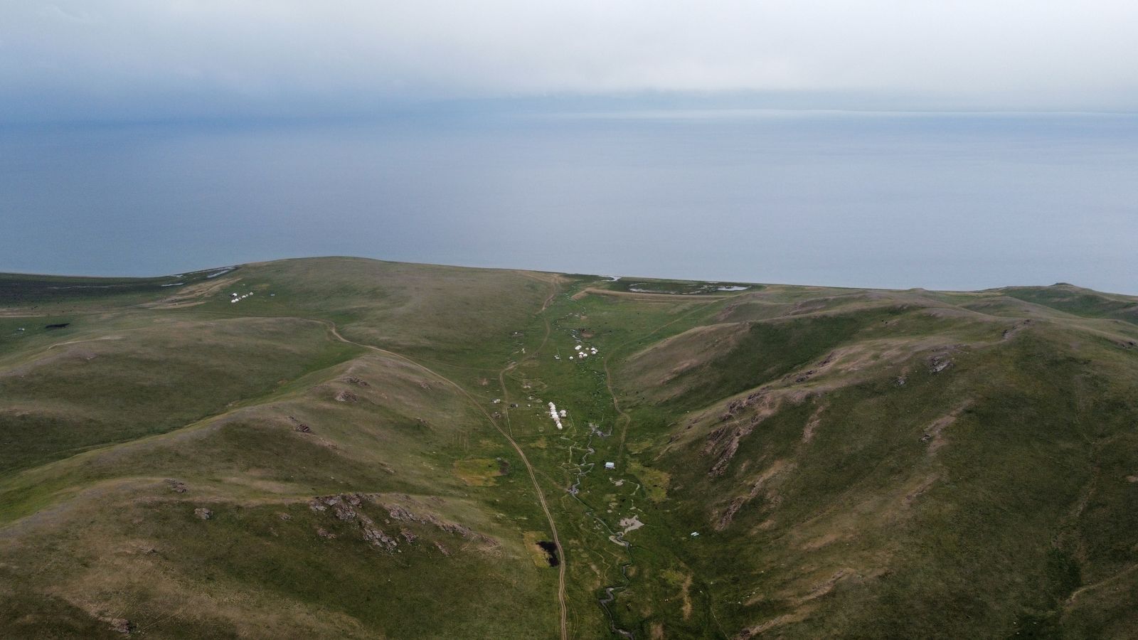 Song-Kul lake from above, with a yurt camp in a side valley